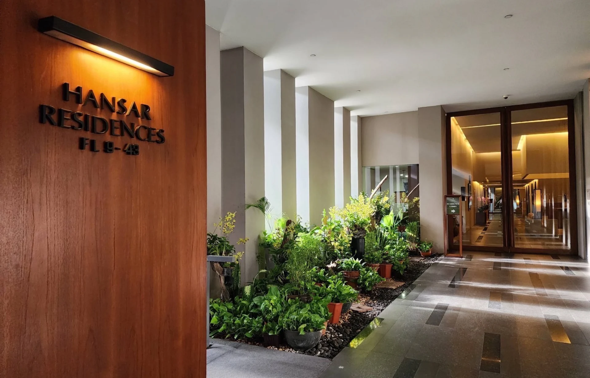 Hansar Residence Rajdamri residences entrance corridor with planted courtyard